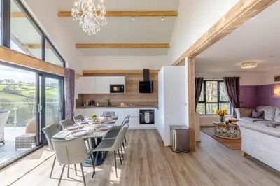 a dining room and living room with a table and chairs at 4 Bed in Berriew oc-t31114 in Berriew