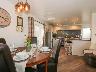 a kitchen and dining room with a table and chairs at Blockley Lodge in Church Stretton
