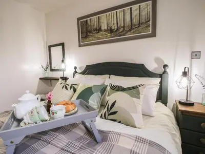 a bedroom with a bed with a tray of food on it at Blockley Lodge in Church Stretton
