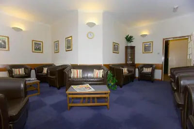 a waiting room with leather couches and a table at Elan Valley Lodge in Llanwrthwl