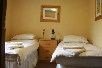 two beds in a room with towels on them at Elan Valley Lodge in Llanwrthwl