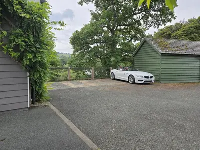 a white car parked in a driveway next to a garage at The Loft at Box Bridge in Brecon