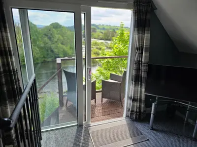 a sliding glass door leading to a balcony with a view at The Loft at Box Bridge in Brecon