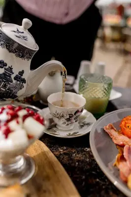 a teapot pouring tea into a cup on a table at Sweeney Hall Hotel in Oswestry