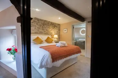 a bedroom with a bed and a stone wall at Y Castell in Llangadog