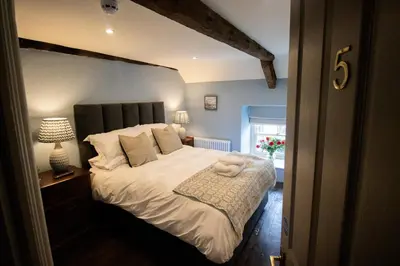 a bedroom with a bed with a teddy bear on it at Y Castell in Llangadog