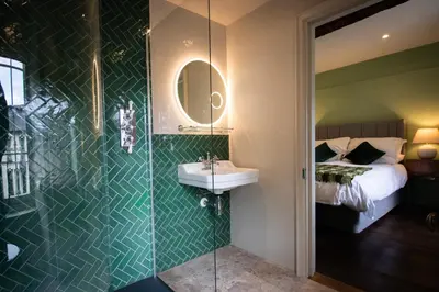 a bathroom with a sink and a shower with a bed at Y Castell in Llangadog