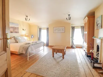 a bedroom with a bed and a fireplace at Mor Iwerddon in Barmouth