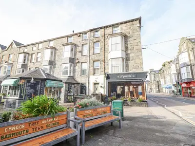 two benches on a street in front of a building at Mor Iwerddon in Barmouth