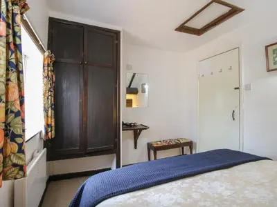 a bedroom with a bed and a closet and a door at The Millers Roost at Dudgeley Mill in Church Stretton