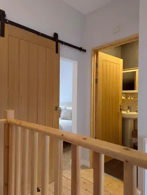 a stairway with a wooden door and a bedroom at Relaxing Coastal Retreat for 2 Hot Tub Log Fire in Tywyn