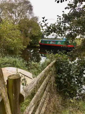 a boat on a river with a wooden fence at The Sitting Duck in Greet