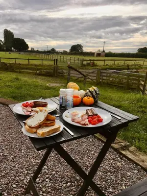 a picnic table with plates of food on it at The Sitting Duck in Greet