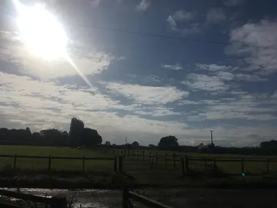 a sun shining in the sky over a field at The Sitting Duck in Greet