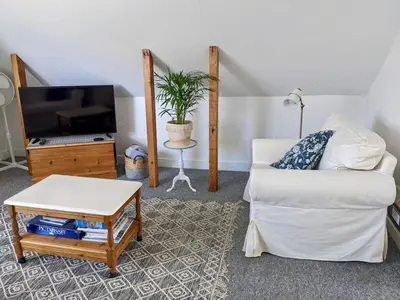 a living room with a white couch and a tv at The Loft - Shrewsbury in Shrewsbury