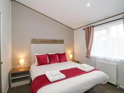a bedroom with a large white bed with red pillows at Peony in Leominster