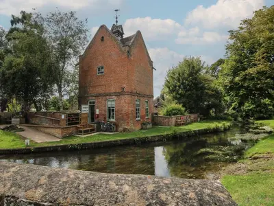 an old brick building next to a river at Peony in Leominster