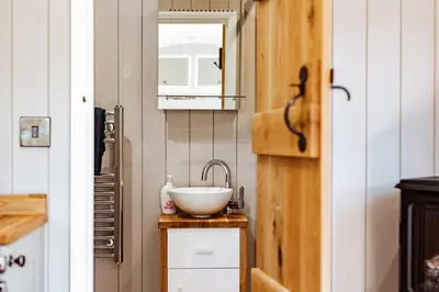 a bathroom with a bowl sink and a mirror at Shepherd's Hut at Lythwood, Near Shrewsbury in Baystonhill