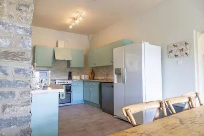 a kitchen with blue cabinets and a white refrigerator at 4 bed cottage Breath-taking views Sleeps 8 in Presteigne