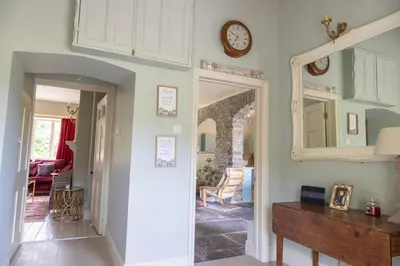 a hallway of a home with a clock on the wall at 4 bed cottage Breath-taking views Sleeps 8 in Presteigne