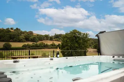 a swimming pool with a view of the countryside at Stud Farm House in Bleddfa