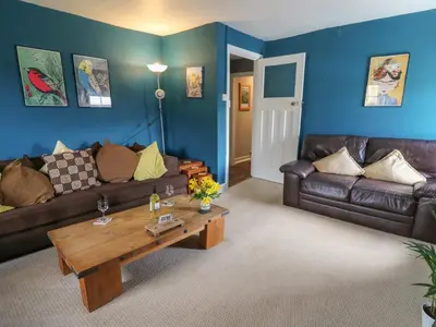 a living room with leather couches and a coffee table at Cantref House Top Floor in Brecon