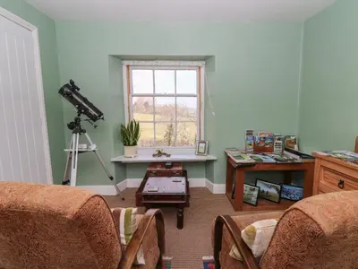 a living room with a camera and a table with chairs at Cantref House Top Floor in Brecon