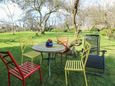 a table with four chairs and a table with flowers on it at Cantref House Top Floor in Brecon