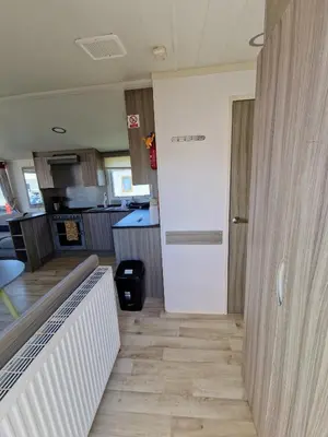 a room with a white door and a kitchen at Sea Breeze Retreat 2 Bedroom Pet Friendly Caravan in Clarach Bay in Aberystwyth