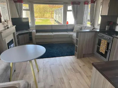 a kitchen and living room with a couch and a table at Sea Breeze Retreat 2 Bedroom Pet Friendly Caravan in Clarach Bay in Aberystwyth