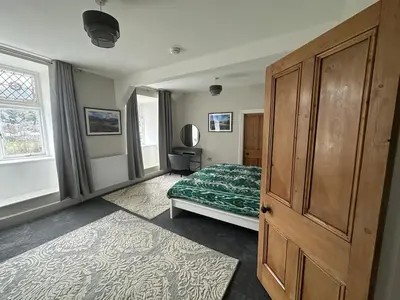 a bedroom with a bed and a wooden cabinet at Cil-y-Coed in Dolgellau