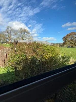 a view of a field from a window at Cosy cottage in Snowdonia hamlet in Frongoch