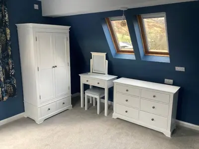 a bedroom with white furniture and a desk and a window at Tyn-Y-Berth Sleeps 27 luxury group accommodation in Tal-y-llyn