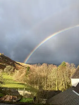 a rainbow in the sky over a field at Tyn-Y-Berth Sleeps 27 luxury group accommodation in Tal-y-llyn