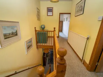 a hallway with a wooden staircase with a stair case at Quintessentially English 3-Bed Home in Ludlow - Pass the Keys in Ludlow