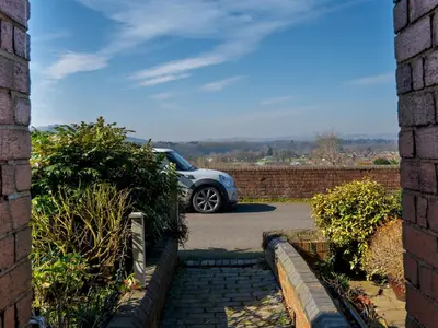 a car parked in a driveway with a brick wall at Quintessentially English 3-Bed Home in Ludlow - Pass the Keys in Ludlow