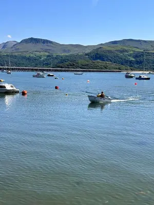 a man in a boat on a body of water at Bermo Cwtch in Barmouth