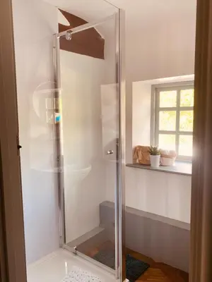a shower with a glass door in a bathroom at North Cottage in Berriew