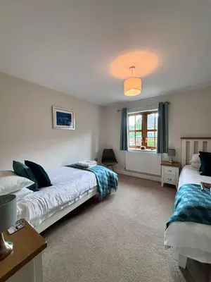 a bedroom with two beds and a window at Minafon in Llanbedr