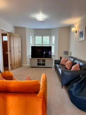 a living room with two couches and a flat screen tv at Minafon in Llanbedr
