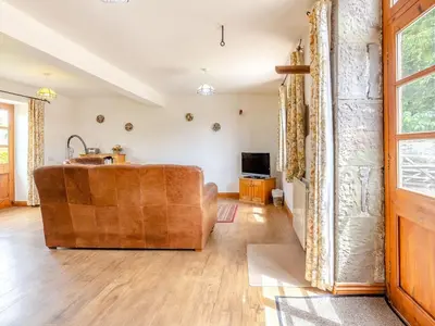 a living room with a couch and a television at Swallow's Nest in Craven Arms