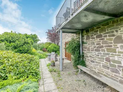 a stone building with a balcony and a bench at Swallow's Nest in Craven Arms