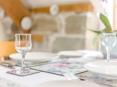 a table with two wine glasses and plates on it at Robin's Nest in Craven Arms