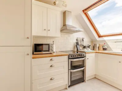 a kitchen with white cabinets and a window at Robin's Nest in Craven Arms
