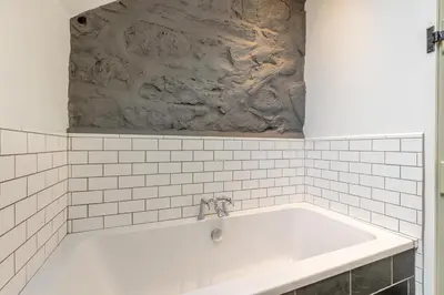 a bath tub in a bathroom with white tiles at 4 Bed in Llangower oc-f31072 in Llangower
