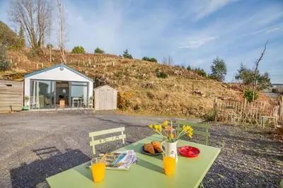 a green table with a vase of flowers on it at 1 Bed in Ffestiniog oc-c31093 in Ffestiniog