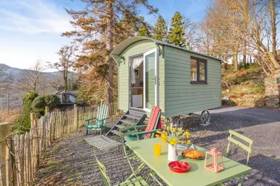 a green tiny house with a table and chairs at 1 Bed in Ffestiniog oc-c31093 in Ffestiniog