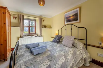a bedroom with a large bed with blue pillows at 2 Bed in Llangorse oc-p31754 in Llangorse