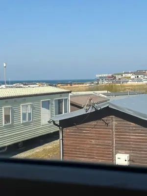 a bird sitting on top of a building with a train at Coastal Serenity Escape Clarach Bay Sea Viev Modern 2019 model No Pets in Aberystwyth
