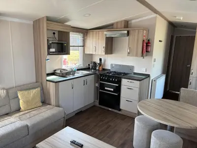 a small kitchen with a couch and a table at Coastal Serenity Escape Clarach Bay Sea Viev Modern 2019 model No Pets in Aberystwyth